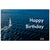 A rectangular birthday card or print featuring a blue ocean scene with a small sailboat and the words 'Happy Birthday' in large white text, with the name 'Gill' in the lower right corner.